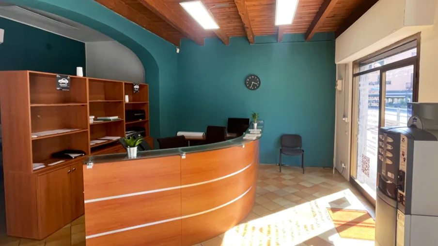Interno Agenzia Oasis Pratiche Auto Treviglio - reception con bancone in legno e pareti color teal